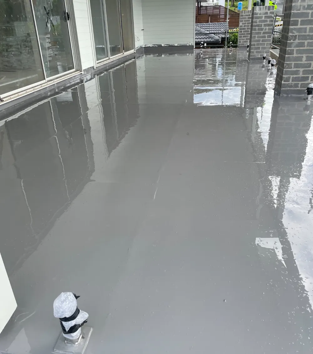 Long upper-floor balcony in glossy grey membrane with glass doors