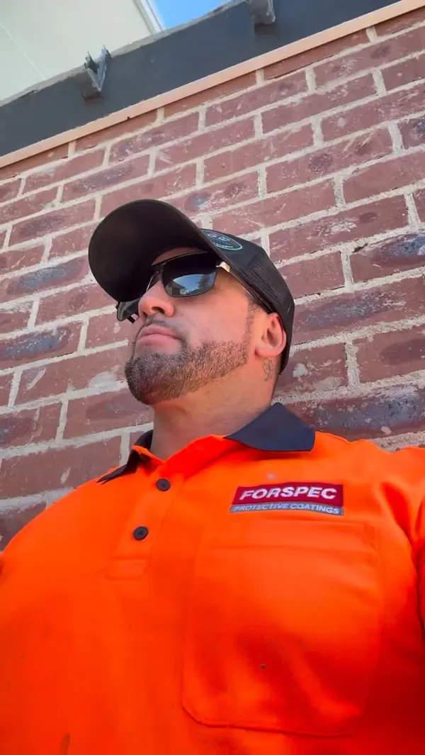 Marty, owner and waterproofing technician at SCW, in an orange Forspec shirt and cap