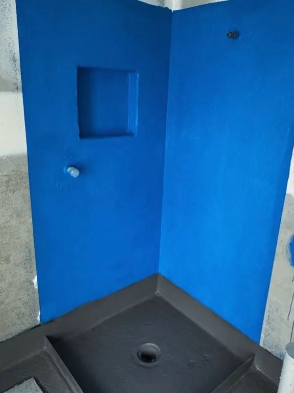 Bright blue membraned shower recess with a black hob